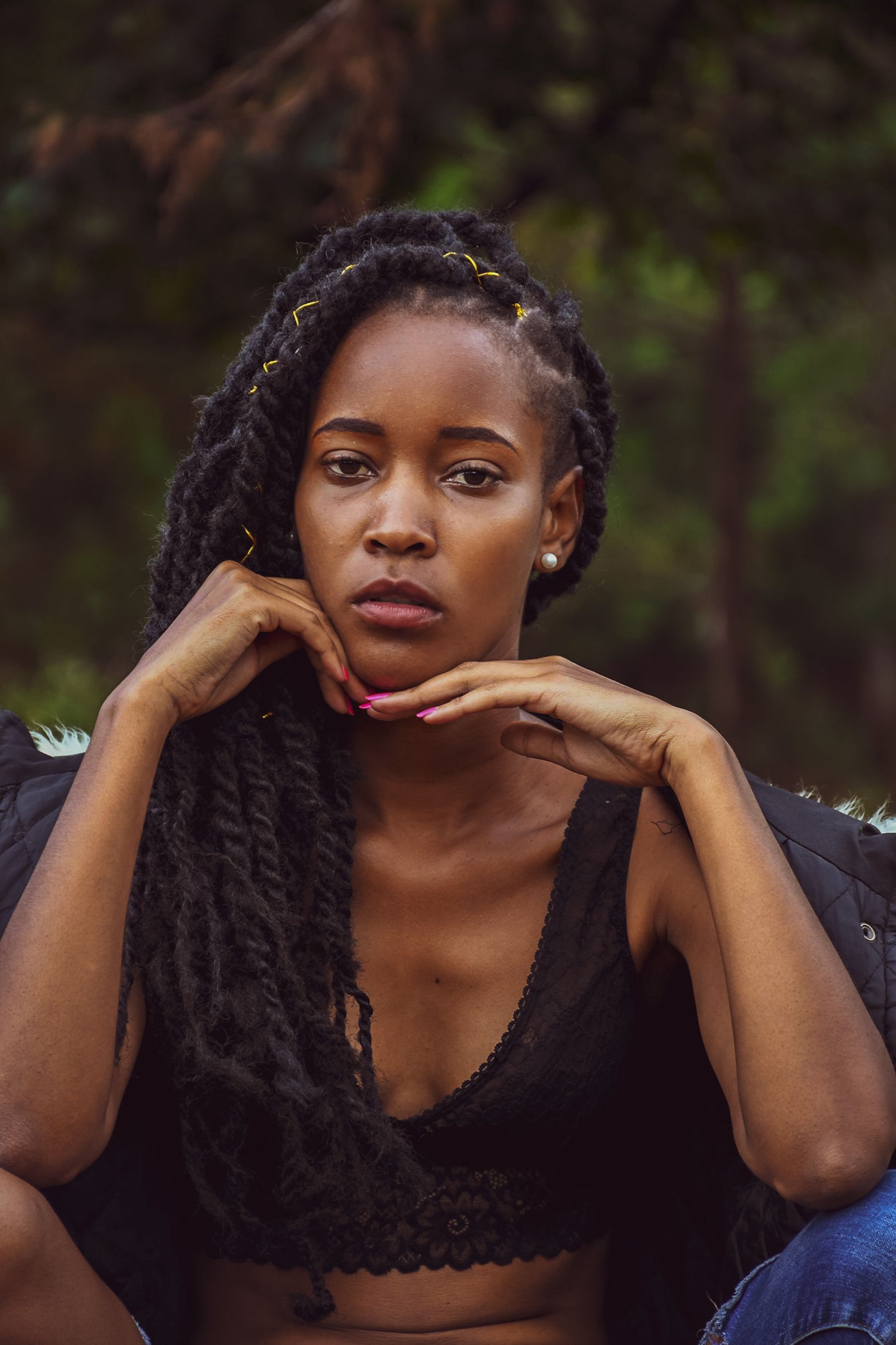 Woman with locs resting her chin on her hands